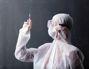 medic woman wearing protective clothing against the virus with syringe