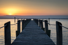 WOODEN PIER OVER SEA AGAINST SKY DURING SUNSET
