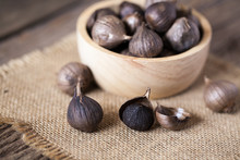 Black Garlic On Sack Cloth And Wooden Table