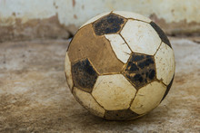 Close-Up Of Abandoned Soccer Ball On Footpath Against Wall