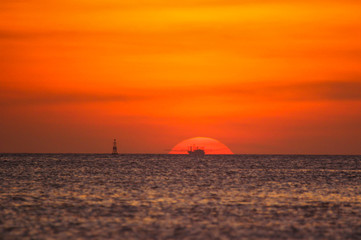 Fishing boat in the ocean on a sunset background