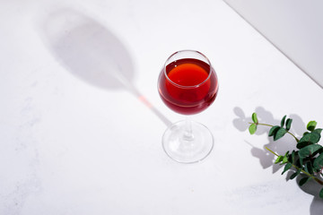 red wine in a wineglass with shadows isolated on stone background