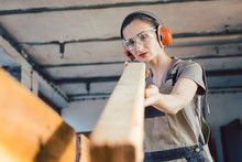 Beautiful Woman Carpenter Checking Quality Of A Plank
