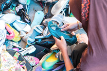 Close Up Of Woman Hand Is Choosing A Secondhand Shoe At Flea Market In Thailand.