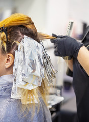 Hands of hairdresser in black gloves dye your hair