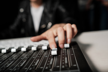 Wall Mural - Female hands adjusting sound controller bars