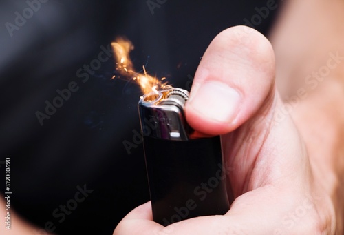 Fotomural Midsection Of Person Igniting Cigarette Lighter