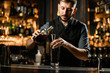 © fesenko - Male bartender pours alcohol from bottle to jigger