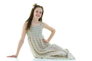 Teen girl posing on the floor in the studio. The concept of styl