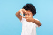 © khosrork - Portrait of curious nosy little boy in T-shirt looking through photo frame shape with fingers, focusing zooming at camera, viewing world with interest. indoor studio shot isolated on blue background