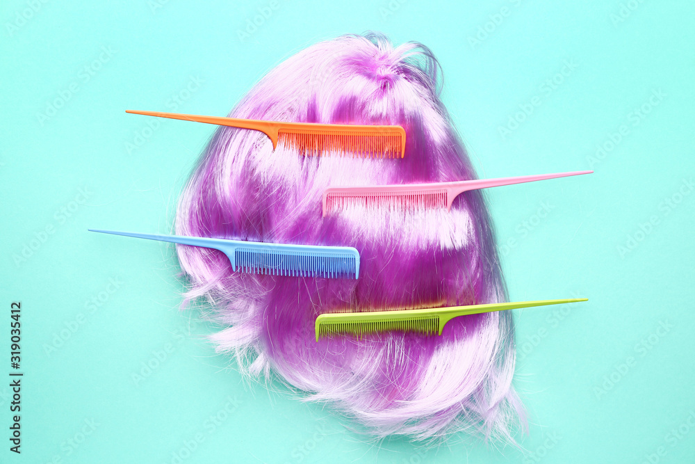 Unusual wig and combs on color background