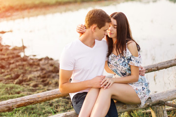 Portrait of happy couple outdoor in nature location at sunset.