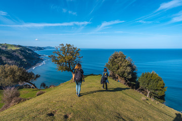 Deba, Gipuzkoa / Spain »; January 26, 2020: Two young people walking along the beautiful coast from Deba to Zumaia