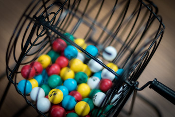 A bingo ball cage with colorful balls inside. 