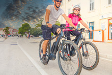Active Couple Riding An E-Bike During Vacations In The South