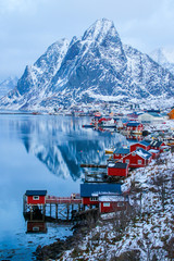 rorbuer in reine in the lofoten islands in winter - view over a snowy mountain on a cloudy day with 