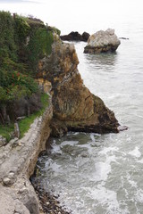 Wall Mural - High angle view of the California coast with a steep cliff and rocks in the water