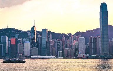 Wall Mural - Star ferry at Victoria Harbor of Hong Kong at sunset. View from Kowloon on HK Island.