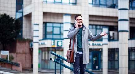 Wall Mural - Optimistic smiling businessman talking on the mobile phone