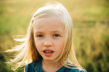 Wall Mural - Funny little girl. Little cute kid. Adorable kid having fun. Carefree child. Emotional little girl on a walk. Happy child playing in summer. Child has summer joy.