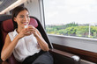 Train commute business woman relaxing enjoying hot coffee cup on first class seat in bus or train. Asian businesswoman lady happy travel lifestyle.