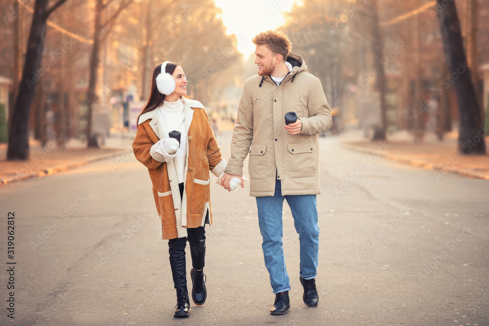 Happy young couple walking outdoors on winter day