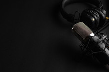 Studio Black Studio Microphone With Studio Headphones On A Black Background. Banner. Radio, Work With Sound, Podcasts.
