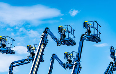 Articulated boom lift. Aerial platform lift. Telescopic boom lift against blue sky. Mobile construction crane for rent and sale. Maintenance and repair hydraulic boom lift service. Crane dealership.