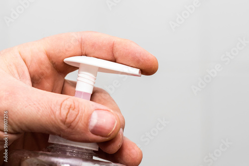 Cuadros en Lienzo man holds in his hand the bottle of liquid soap close-up