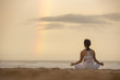 © Zorro Stock images - Yoga lotus pose meditation practice of young Asian female on an beach with rainbow background.