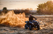 Racing powerful quad bike on the difficult sand in the summer.