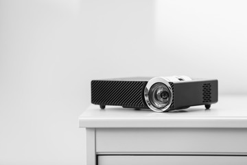 Modern video projector on white table indoors