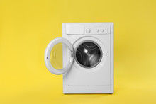 Modern Washing Machine On Yellow Background. Laundry Day