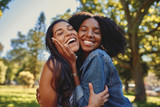 Fototapeta  - Close up lifestyle portrait of diverse multiracial happy best friends hugging each other and laughing in the park
