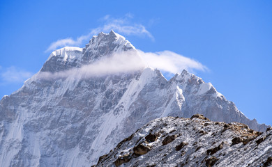 Wall Mural - Majestic Thamserku (6652 m) peak towering above the clouds at sunrise in Nepal, Himalayan mountains