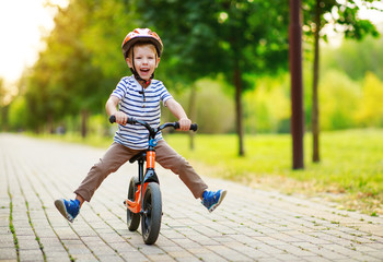 happy child boy rides a racetrack in park in summer