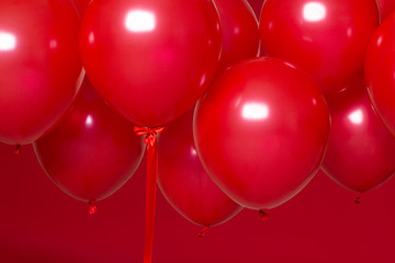 Wall Mural - red helium balloons on red background