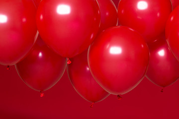 Wall Mural - red helium balloons on red background