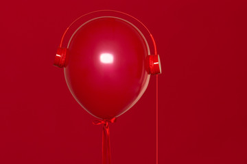 Canvas Print - red helium balloon with red retro headphones on red background