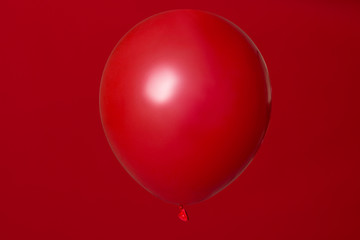 Wall Mural - red helium balloon on red background