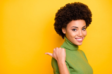 Sticker - Close up turned photo of curly wavy charming woman pointing into empty space behind her back with thumb isolated vivid color background