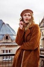 Outdoor Fashion Portrait Of Young Attractive Elegant Woman Wearing Trendy Brown Faux Fur Coat, Beige Beret, Posing In European City