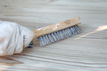 metal brush in hand on wood