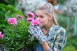 happy  woman gardener choosing flower pot with anthuriums in garden center
