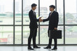 © eakgrungenerd - Asian business partners handshake, successful collaboration.