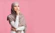 © Prostock-studio - Portrait of thoughtful millennial islamic woman in headscarf over pink background