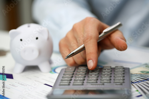 Cuadros en Lienzo Male hand push key silver calculator is lying on desk cash dollar plots in home office setting