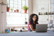 © mavoimages - Smiling young woman using a laptop in her framing shop