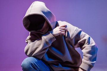 Wall Mural - Modern Epic portrait of bboy in a neon light hoodie. Beneath the hood. Dark face. Mysterious and cool.