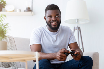 Wall Mural - African american gamer playing on gamepad at home